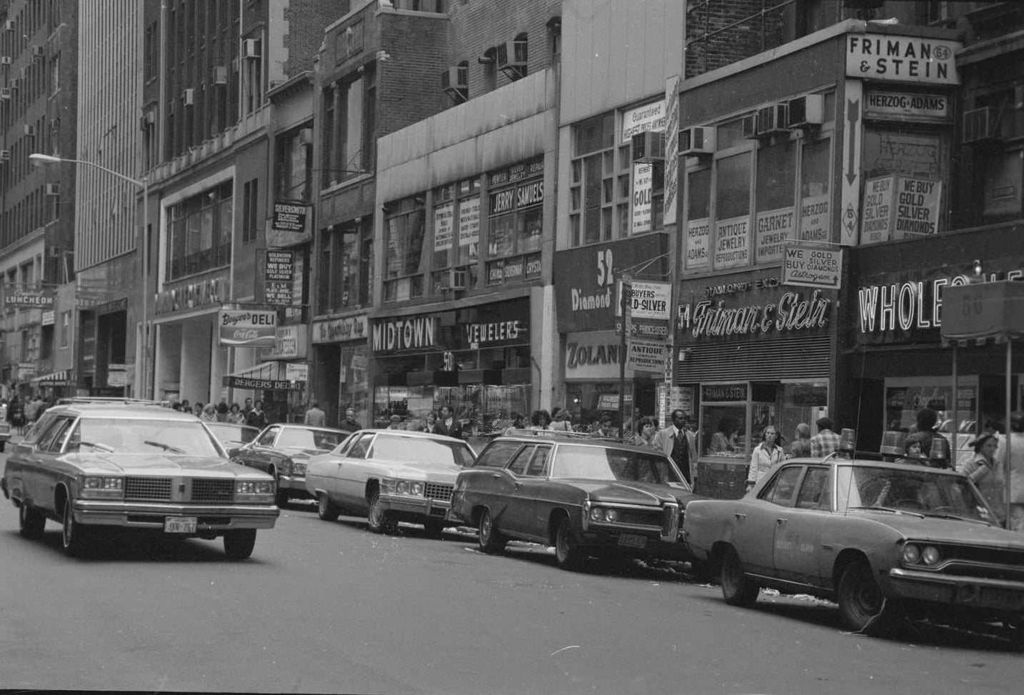 NYC Diamond District in the 1970s. A scene with cars and people on a city street lined with diamond wholesalers.
